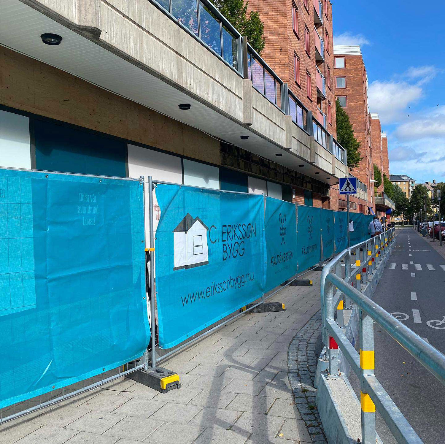 Ett gallerstaket med firmans logga på