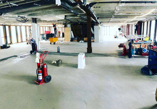 Betonglokal med byggmaskiner.